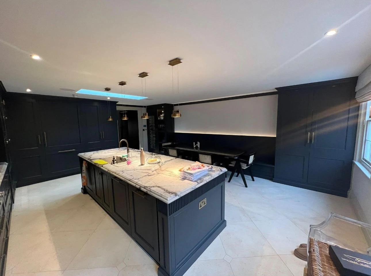 Kitchen island cabinets painted in dark navy in an open-plan kitchen