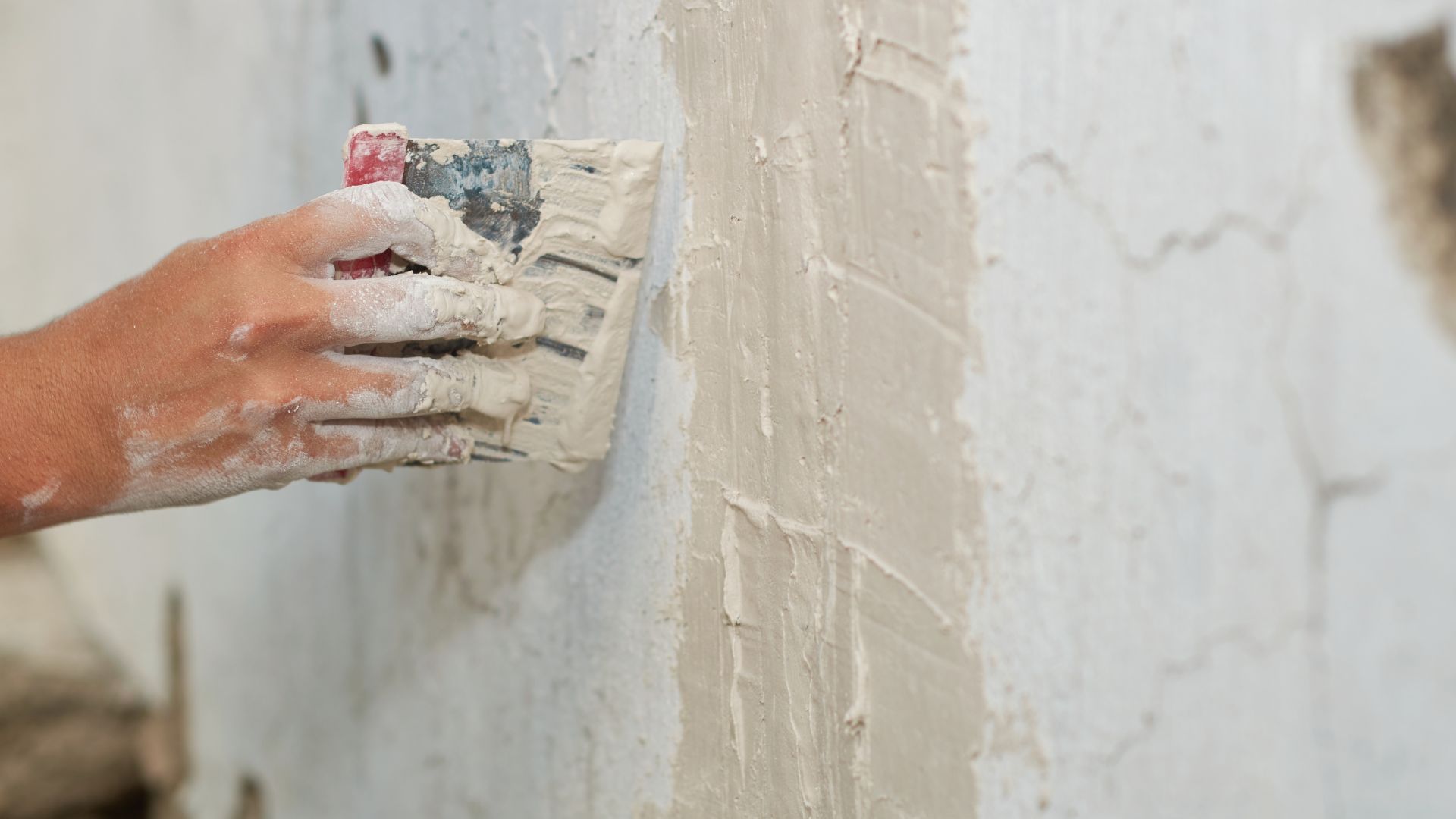 Stock illustration of damaged wall plaster being patched with a filling knife