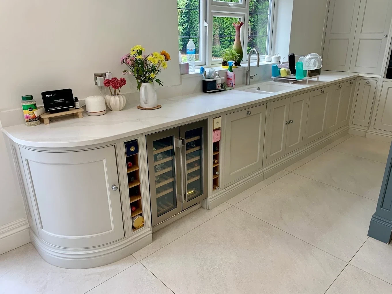 Curved painted kitchen cabinets with built-in wine cooler