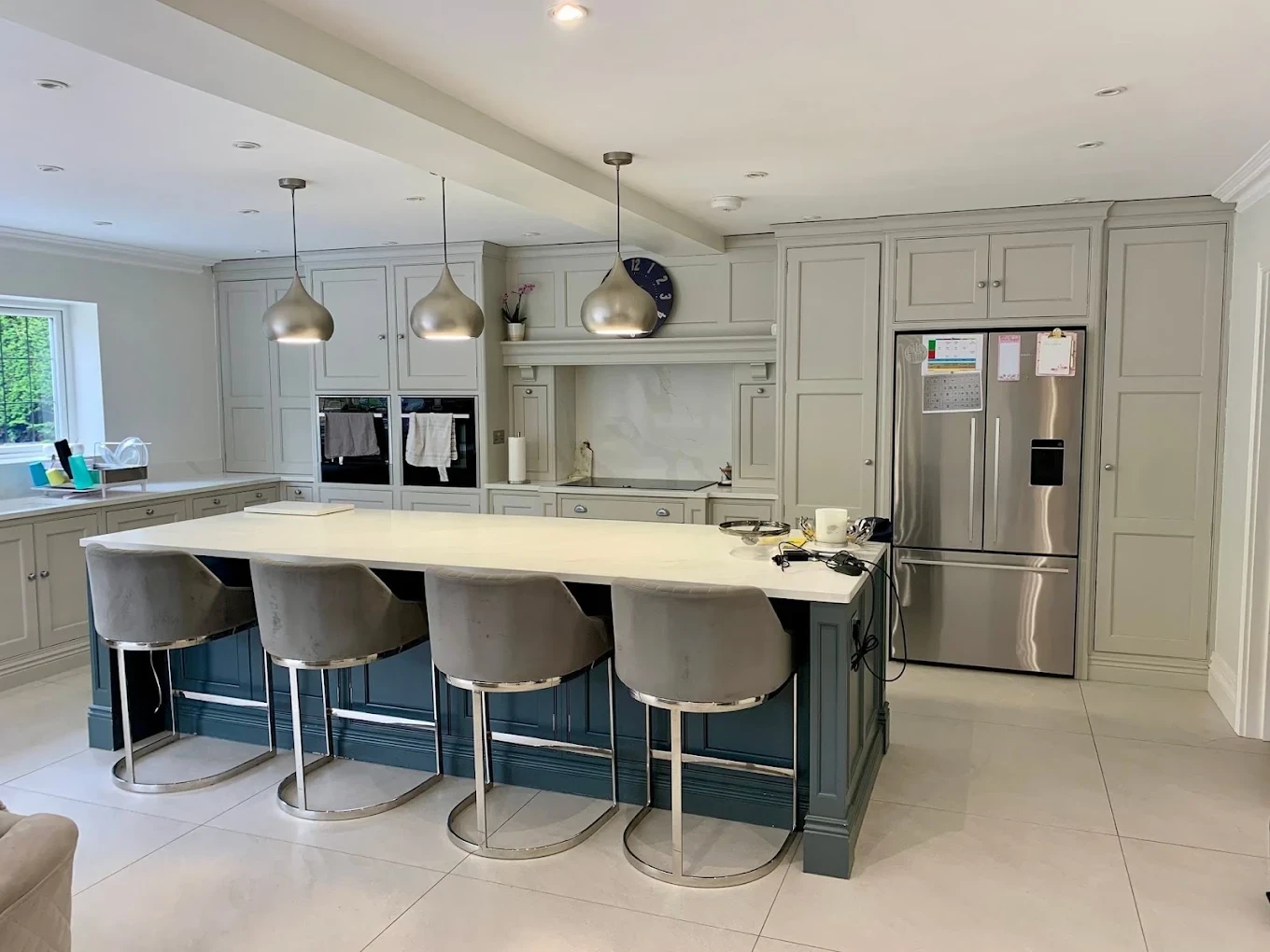 Painted shaker kitchen with grey cabinetry and navy island seating