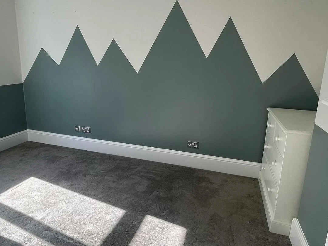 Child's bedroom feature wall painted with a green mountain design