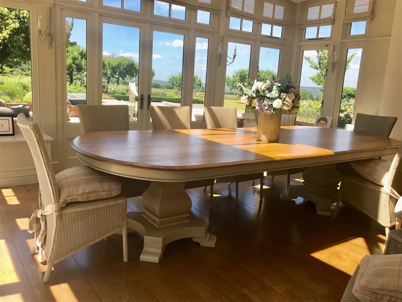 Painted panelled window frames in a garden room with dining table
